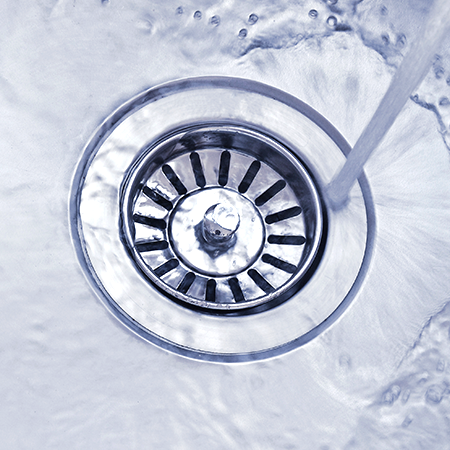 Water flowing into sink drain