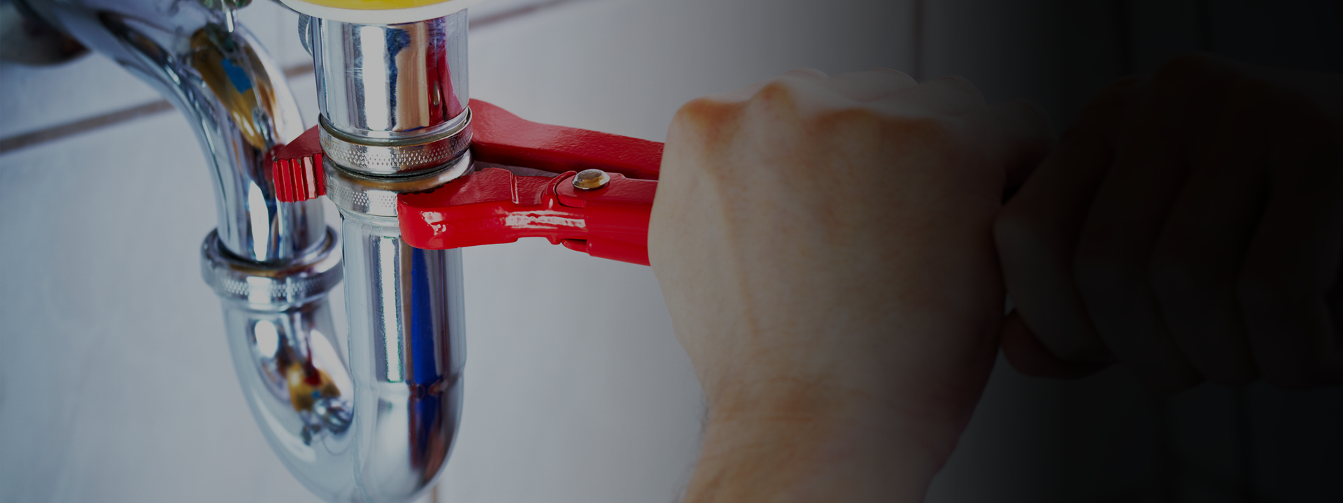 Plumber using wrench on pipe